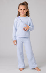 Girl wearing a pale blue ribbed long-sleeve top and matching wide-leg pants with side slits.