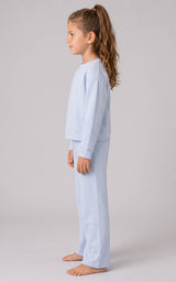 Girl wearing a pale blue ribbed three-piece lounge set with a relaxed long-sleeve top and loose, slit-hem pants.