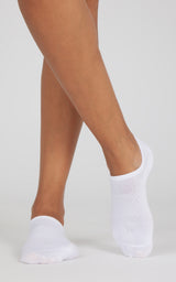 White no-show socks worn on crossed feet, with low-cut, barely visible fabric at the ankles.