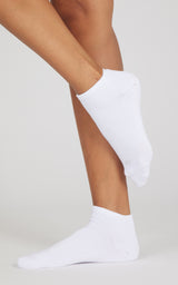 White low-cut socks shown on both feet, with one foot raised to display the ankle-height fit.