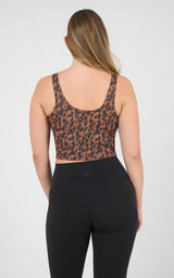Back view of a cropped tank with a leopard-print bodice, black lower panel, and wide shoulder straps.