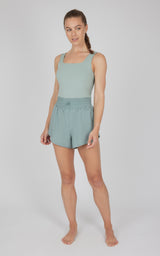 Sleeveless green romper with fitted bodice and relaxed shorts, breathable lightweight fabric.