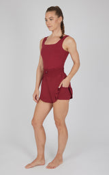 Women's sleeveless Tibetan Red romper with square neckline, belted waist, and side pockets.