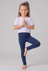 Little girl wearing full-length navy leggings with a smooth stretch fit, posed against a pale gray backdrop.