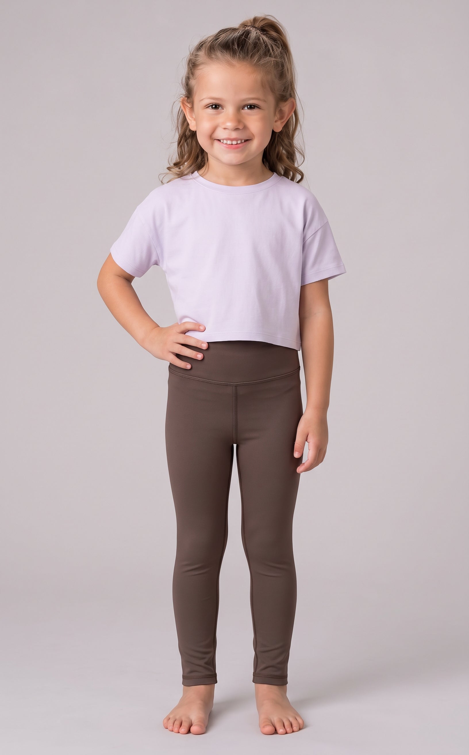 Little girl wearing full-length dark brown leggings with a fitted stretch silhouette and a cropped lavender T-shirt.