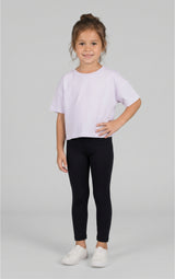 Toddler wearing a light lavender short-sleeve T-shirt, black leggings, and white sneakers.