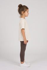 Toddler wearing dark brown full-length leggings with a soft, fitted look, shown from the side.