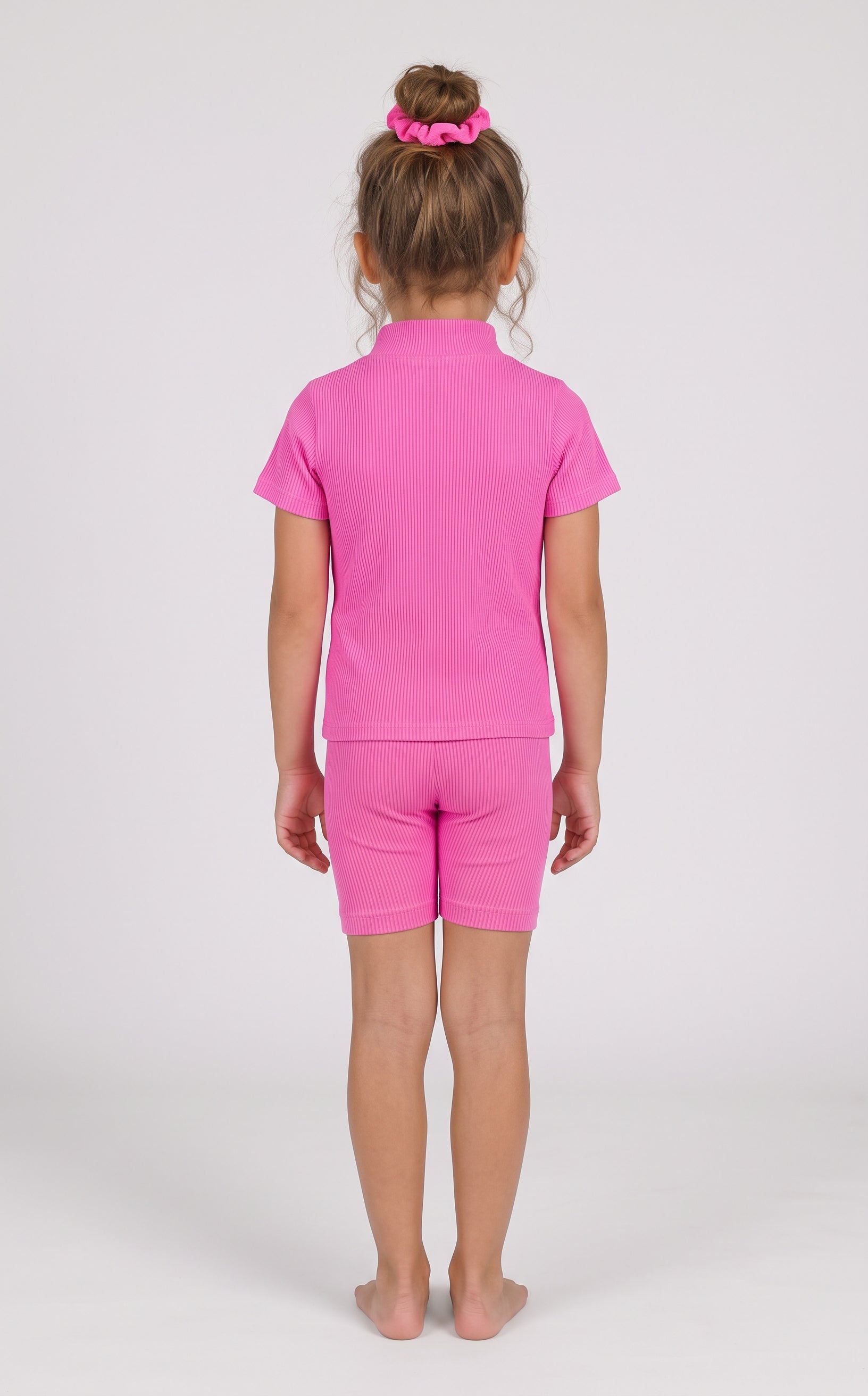 Back view of a toddler girl wearing a bright pink ribbed short-sleeve top and matching fitted shorts.