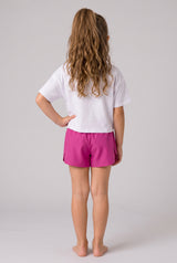 Back view of a girl wearing bright pink flutter running shorts with a white inner short, paired with a white T-shirt.