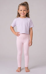 Girl modeling a pale pink cropped T-shirt with matching full-length leggings in a smooth stretch fabric.