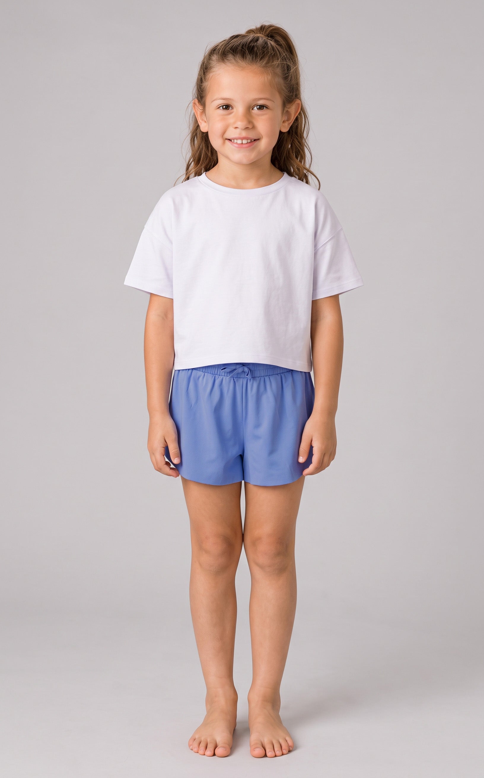Light blue lightweight girls running shorts with flutter-style outer layer and fitted inner lining, worn with a plain white.