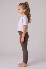 Girl modeling full-length brown leggings with a fitted stretch design and a cropped lavender shirt.