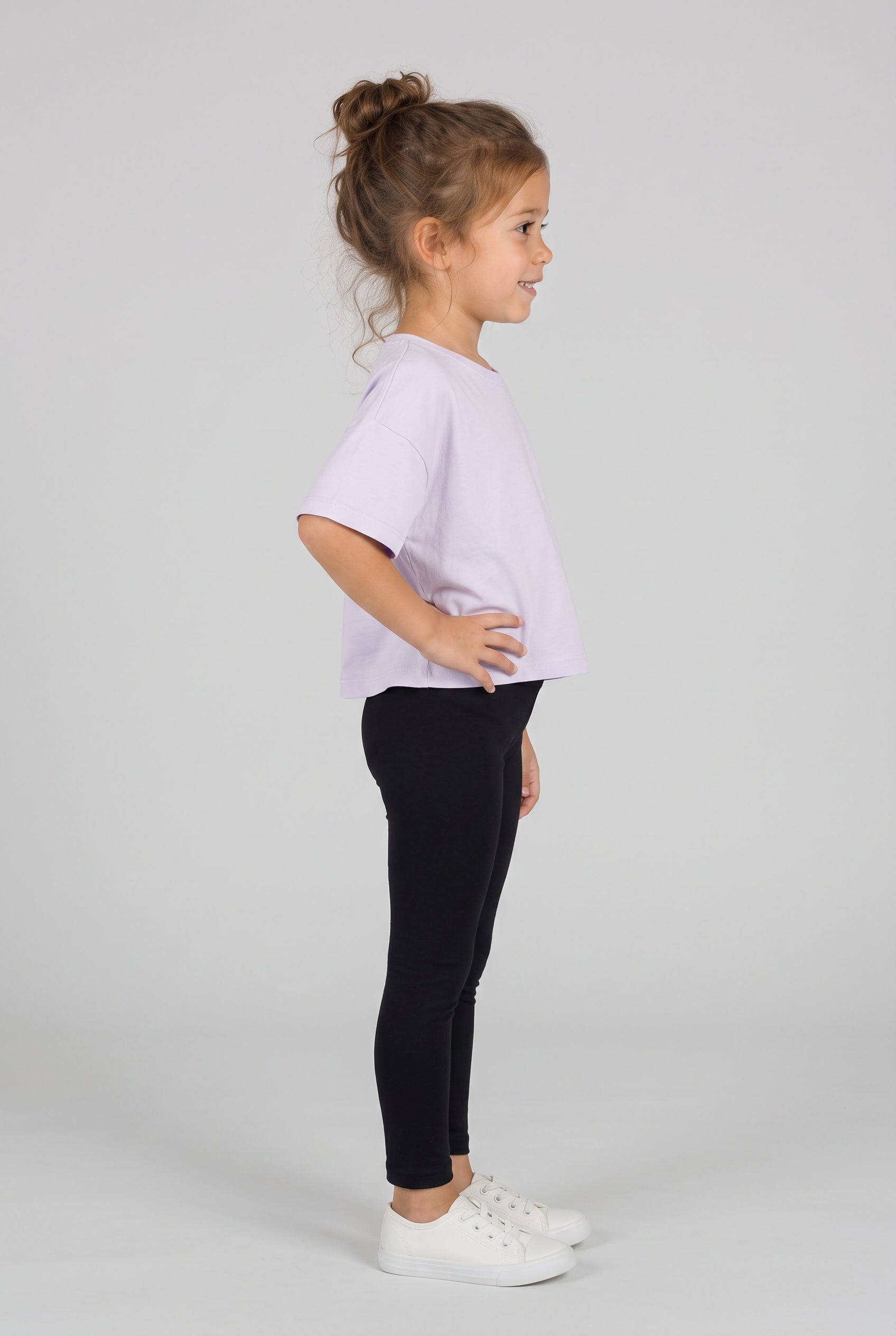 Toddler wearing fitted black leggings with an elastic waist, paired with a lavender tee and white sneakers.