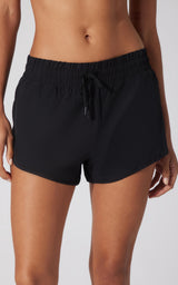 Black lightweight running shorts with elastic waistband and front drawstring closure on female model.
