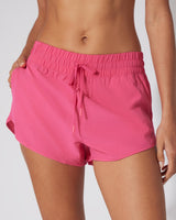 Pink lightweight running shorts with elastic waistband and adjustable drawstring.
