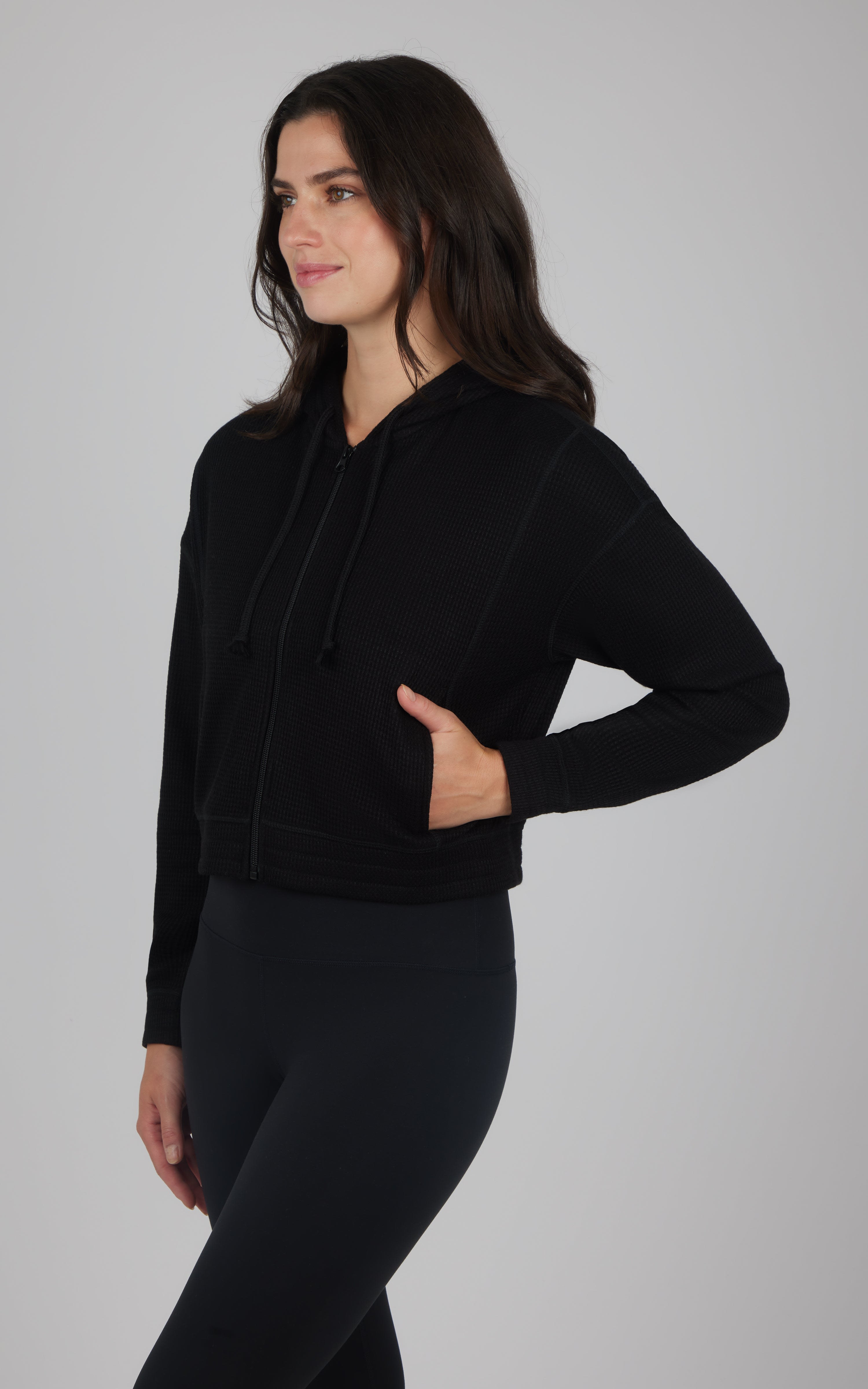 Black brushed inside hooded jacket with front pockets, worn with black leggings.