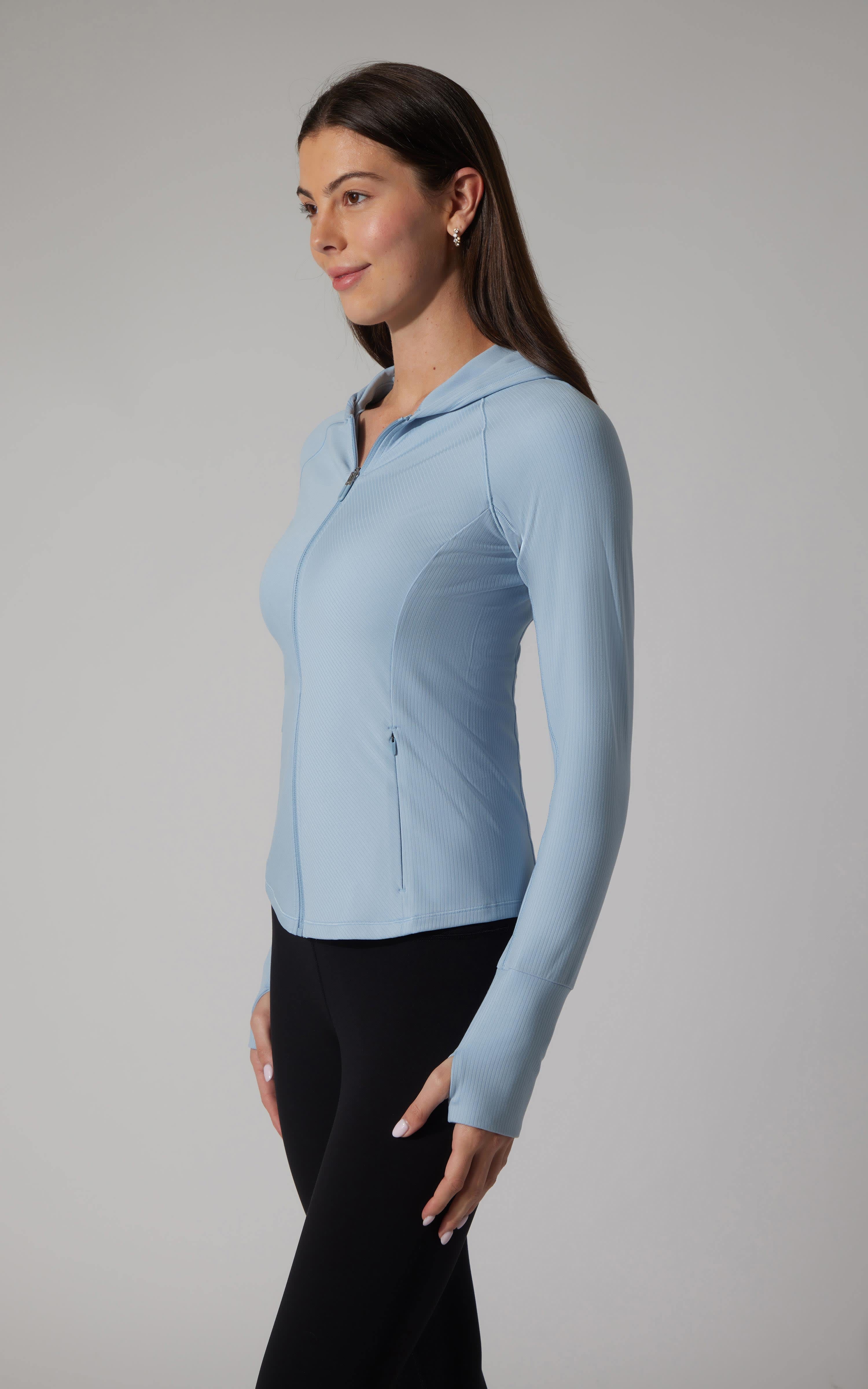 Light blue ribbed full zip hoodie jacket with slim fit and thumbhole cuffs on woman.