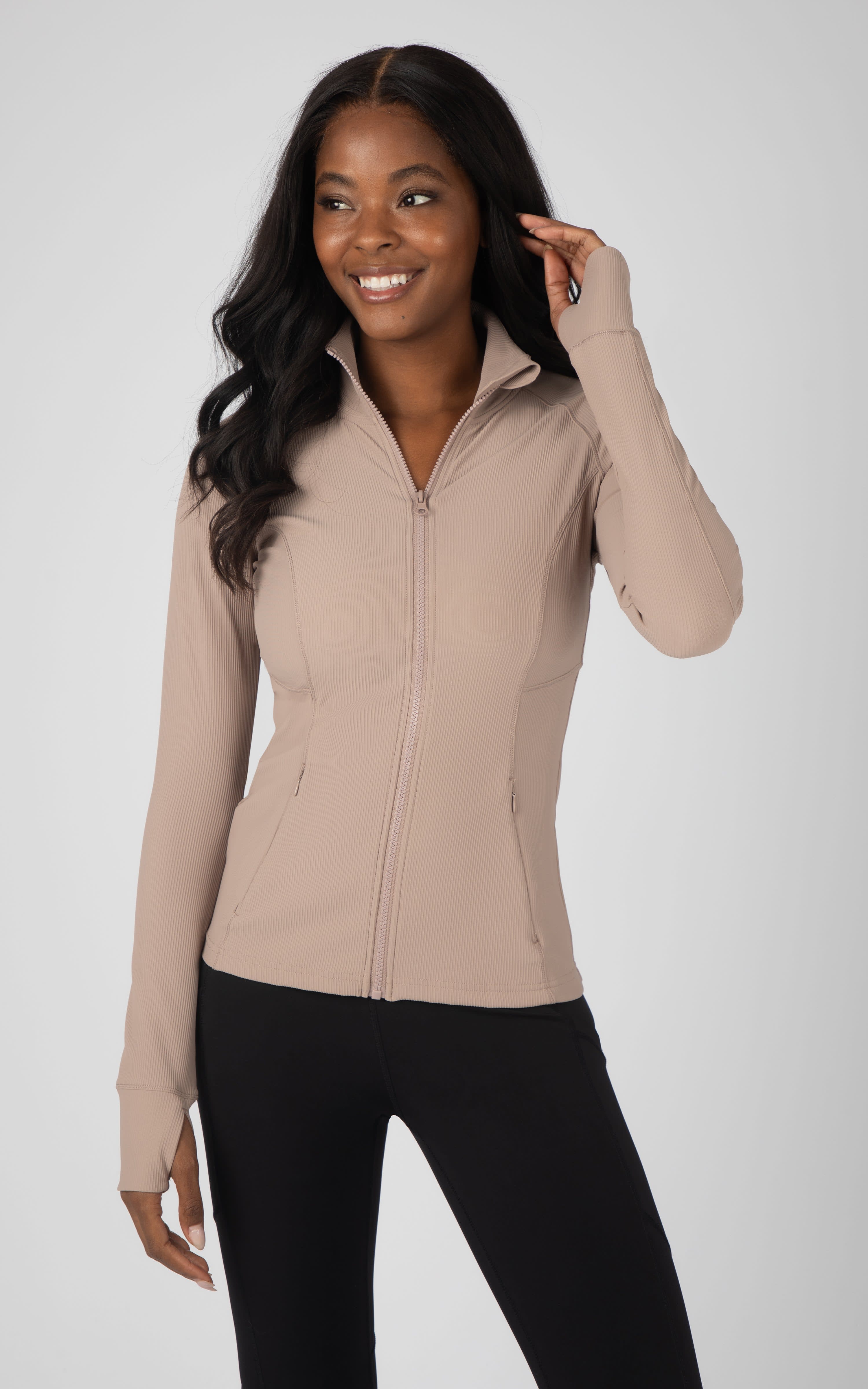 Women's sand ribbed full-zip athletic jacket with thumb holes and high collar.