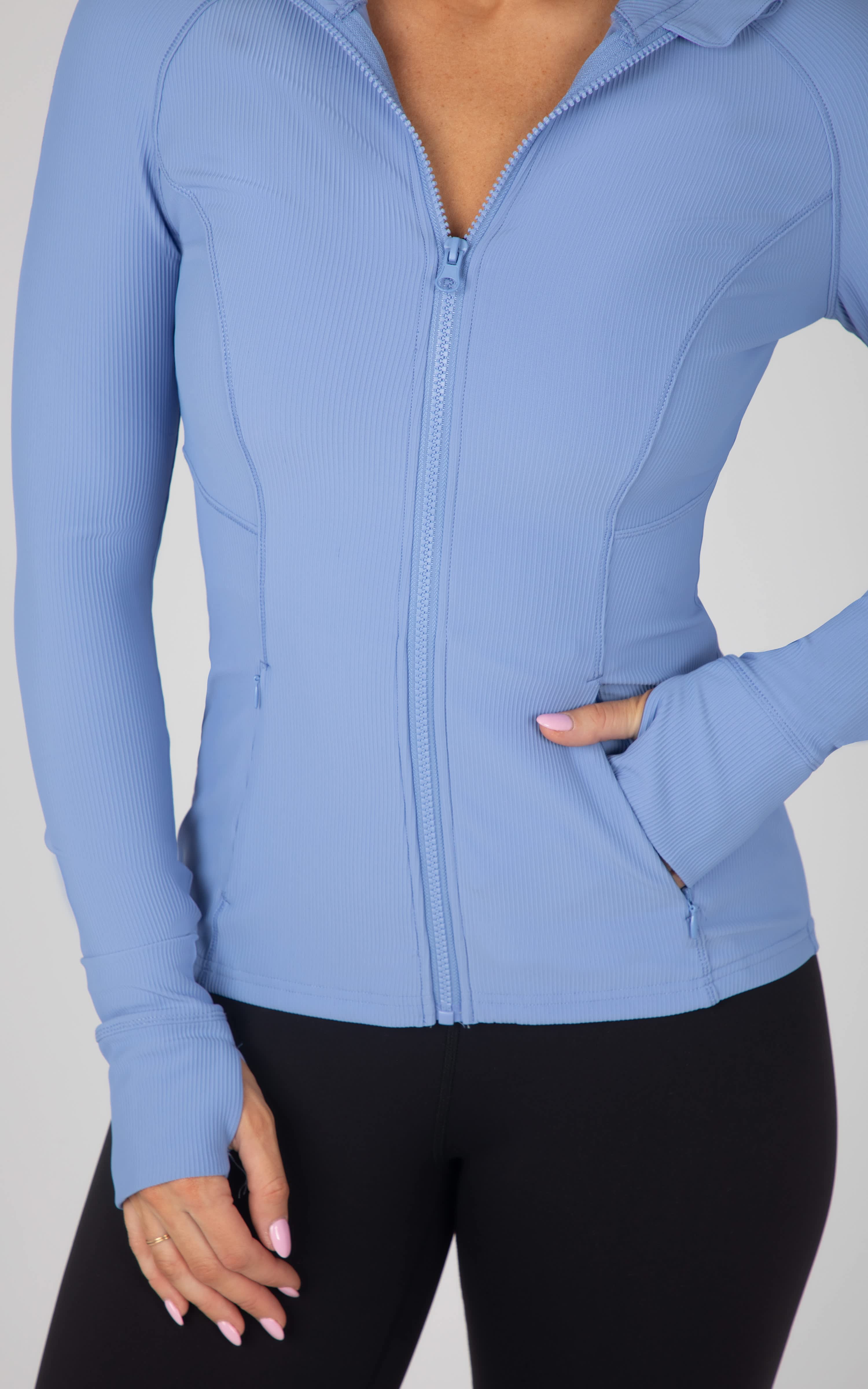 Light blue ribbed full-zip athletic jacket with thumbholes and fitted silhouette.