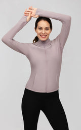 Fitted dusky orchid ribbed jacket with a full zip, mock neck, and long sleeves, paired with black leggings.