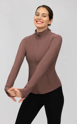 Fitted mauve ribbed performance jacket with a full zip, mock neck, and long sleeves, paired with black leggings.
