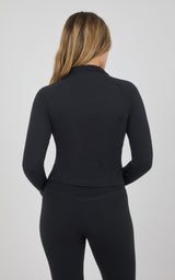 Back view of a black fitted raglan jacket with a raised collar and full zip, paired with matching leggings.