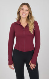 Burgundy full-zip raglan jacket with a fitted silhouette, stand collar, and long sleeves, paired with black pants.