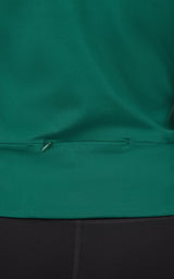 Close-up of dark green full zip jacket hem with adjustable drawstring and smooth fabric texture.