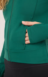 Women's forest green full zip athletic jacket with thumbhole cuffs and side pockets.