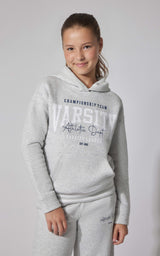 Light grey fleece pullover hoodie with navy varsity-style lettering and front kangaroo pocket on girl model.