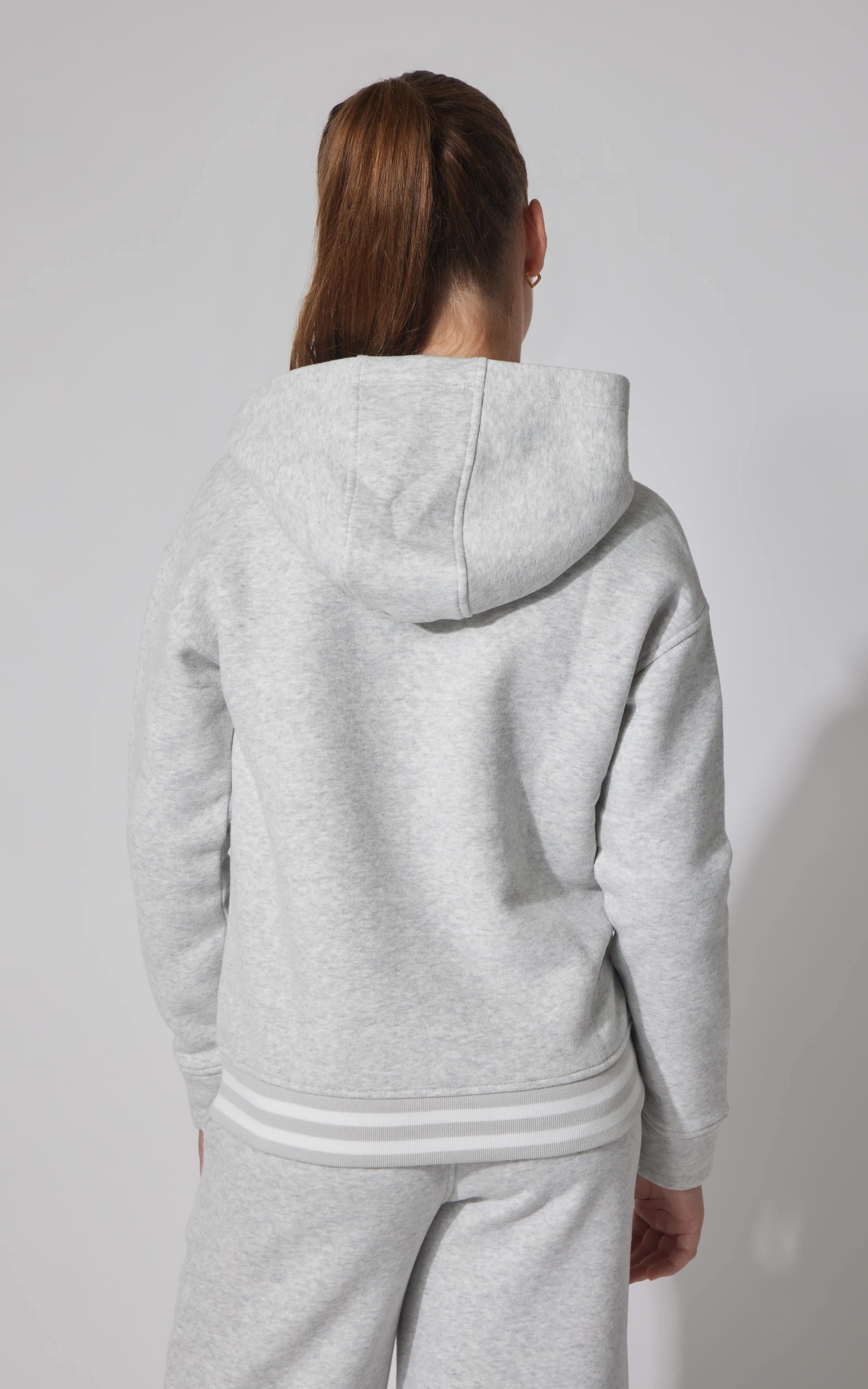 Light gray fleece pullover hoodie with hood and ribbed cuffs and hem on a girl viewed from the back.