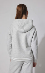 Light gray fleece pullover hoodie with hood and ribbed cuffs and hem on a girl viewed from the back.