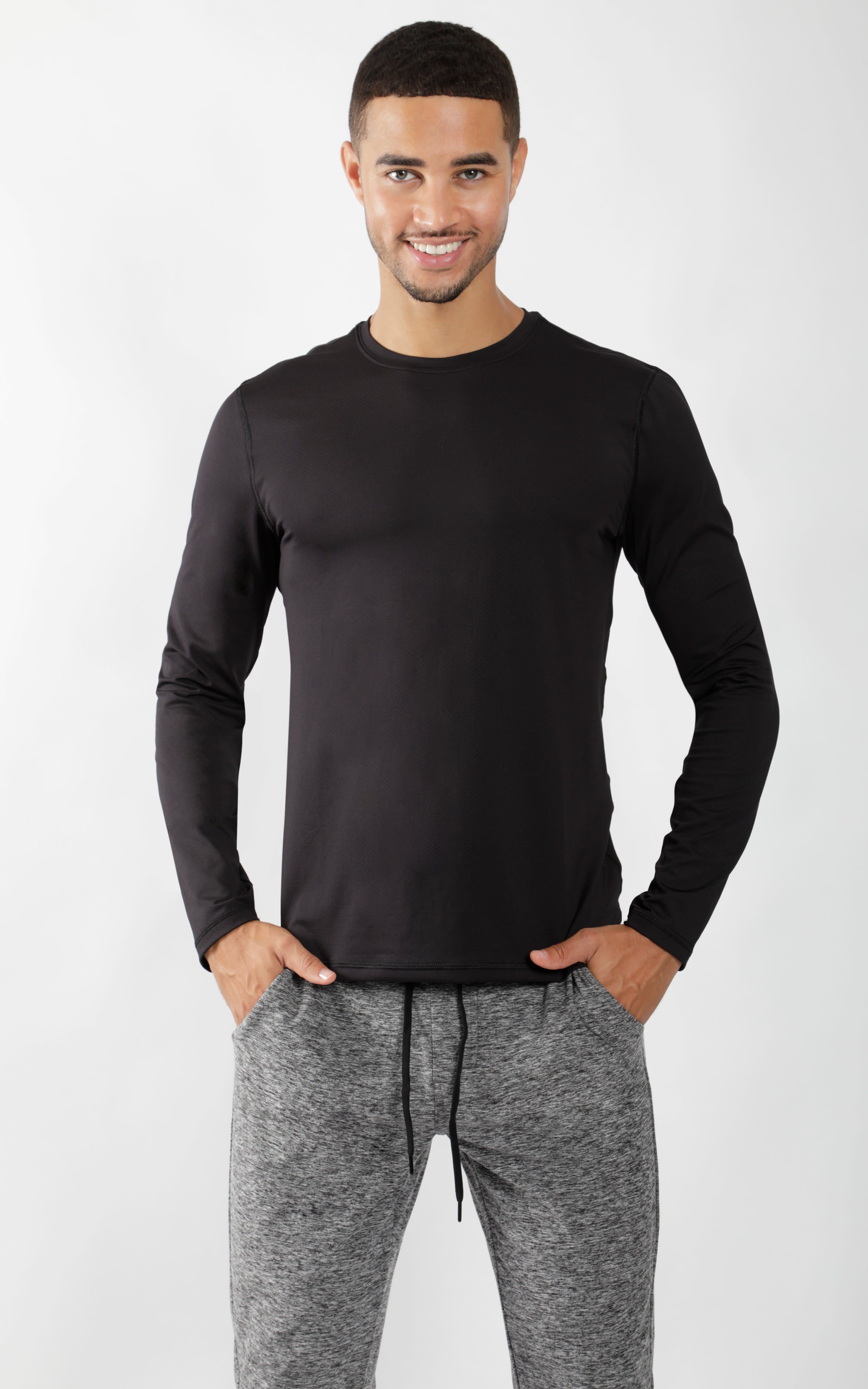 Men's black crew neck long sleeve shirt with slim fit on model with gray jogger pants.