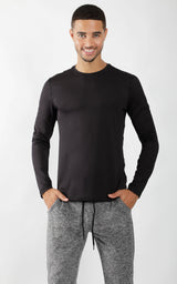 Men's black crew neck long sleeve shirt with slim fit on model with gray jogger pants.