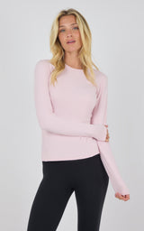 Light pink fitted long sleeve top with crew neckline, worn with black leggings.
