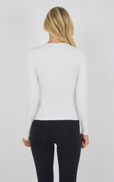 Back view of a fitted long sleeve top in soft chalk pink with a crew neckline and smooth fabric.
