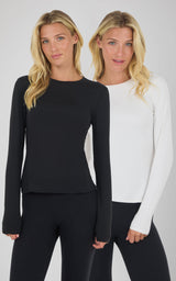 Two women wearing Zenly Zena long sleeve tops, one in black and one in white, paired with black leggings.