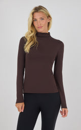 Dark brown mock neck long sleeve top with fitted silhouette on model.