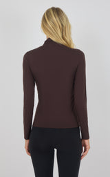 Dark taupe mock neck long sleeve top with slim fit on woman viewed from back.