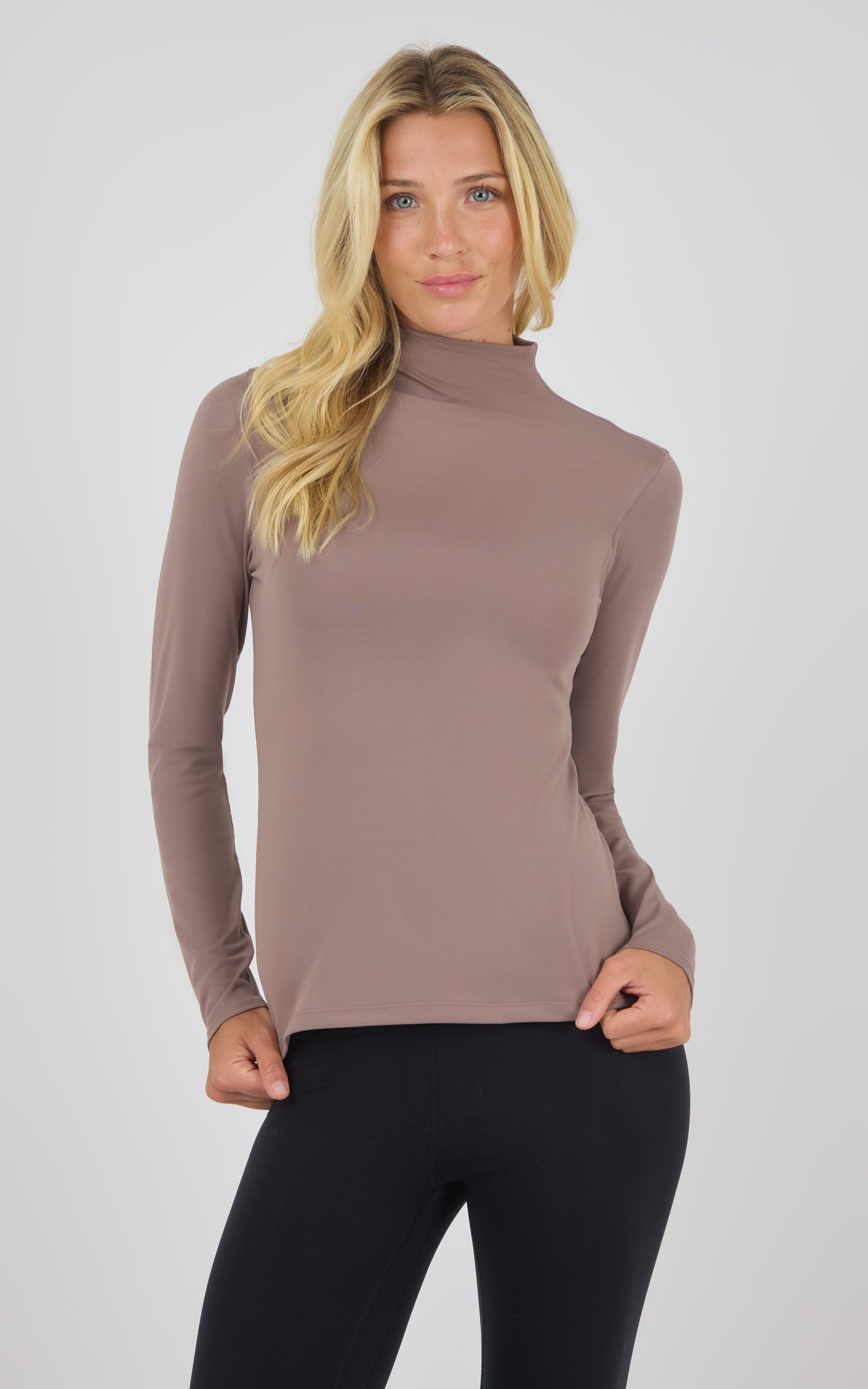 Long sleeve mock neck top in deep taupe with fitted silhouette on model.