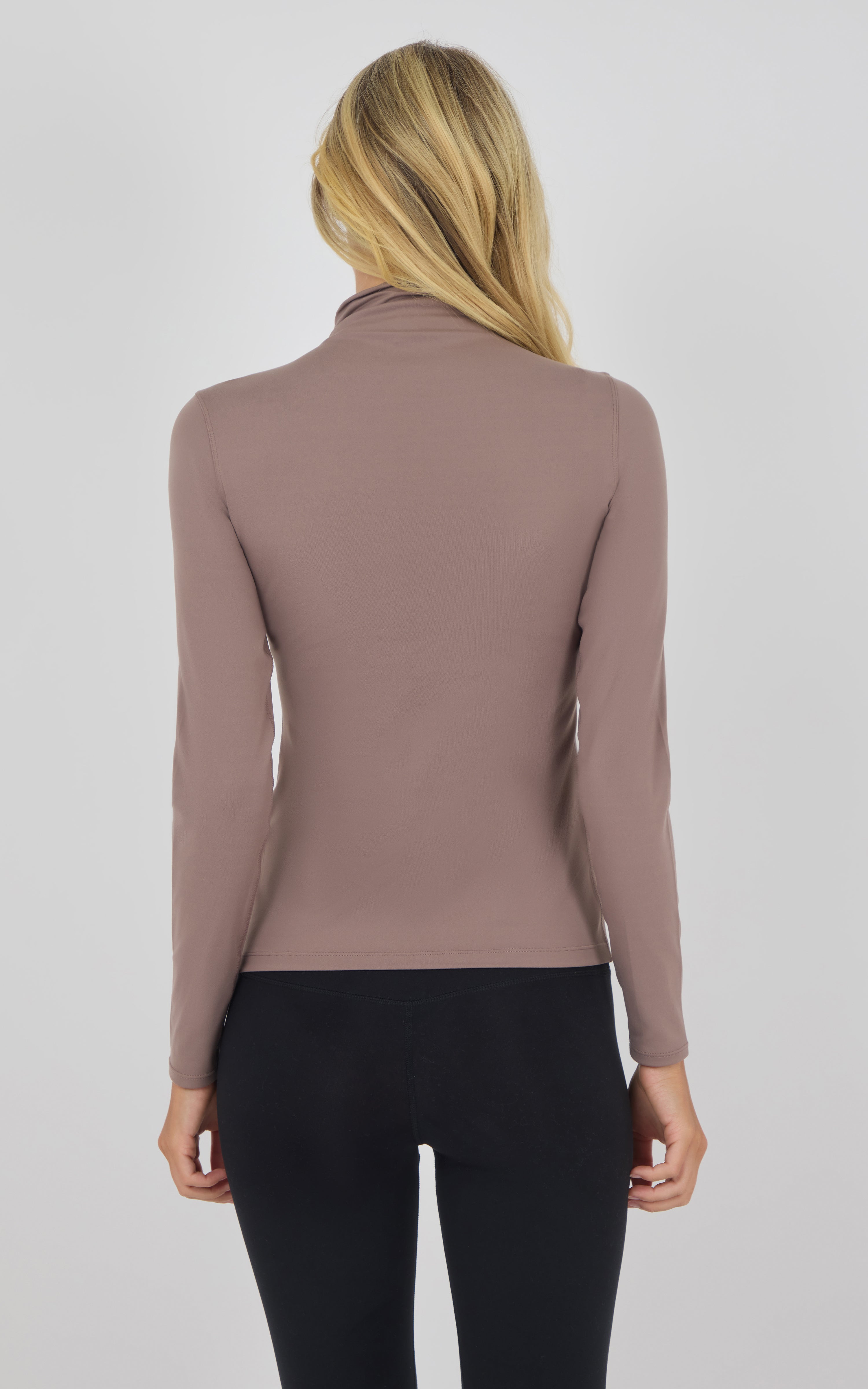 Slim-fit long sleeve mock neck top in deep taupe, back view on blonde model.