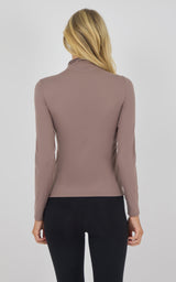 Slim-fit long sleeve mock neck top in deep taupe, back view on blonde model.
