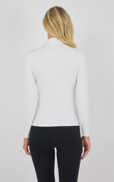 White mock neck long sleeve top with fitted silhouette on woman from back.