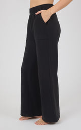 Black marled pique wide-leg pants with a smooth waistband and relaxed drape, shown from the side.