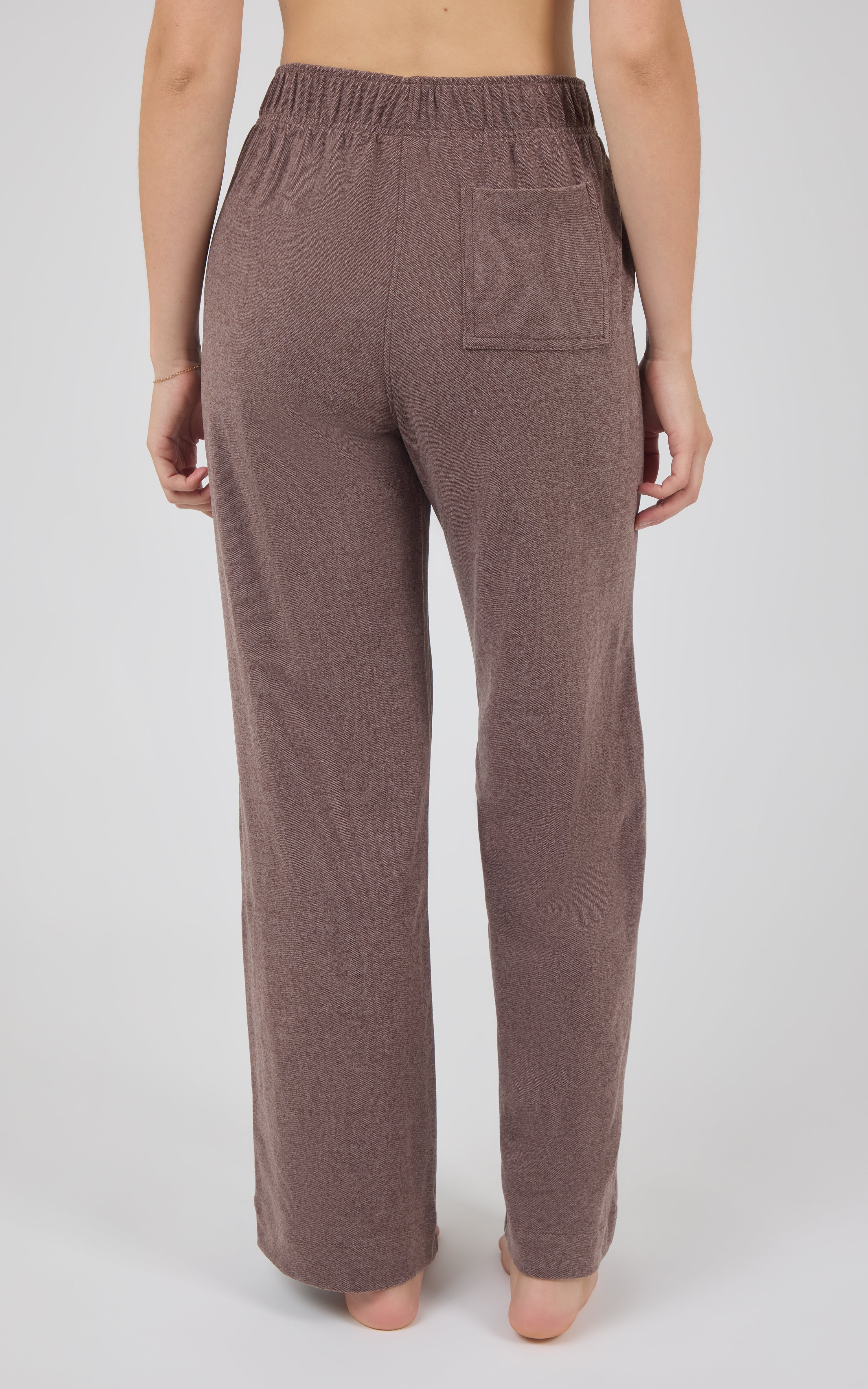 Back view of mauve-brown marled pique wide-leg pants with an elastic waistband, rear pockets, and full-length straight hems.