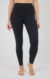 Black high-rise full-length fleece tights with a wide waistband and snug, tapered fit, shown on a model.