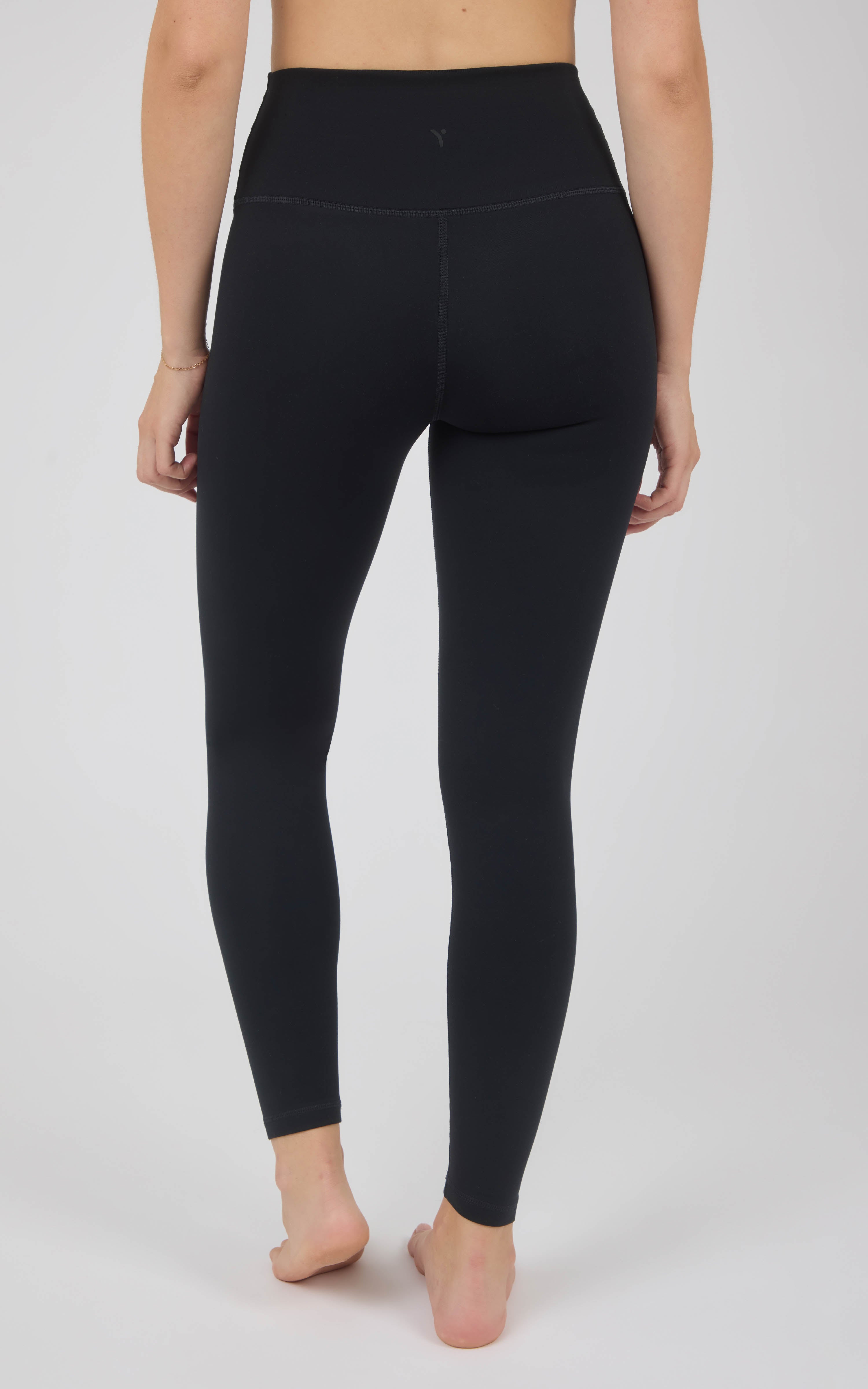 Black full-length high-rise leggings with a smooth, close fit and wide waistband, shown from the back.
