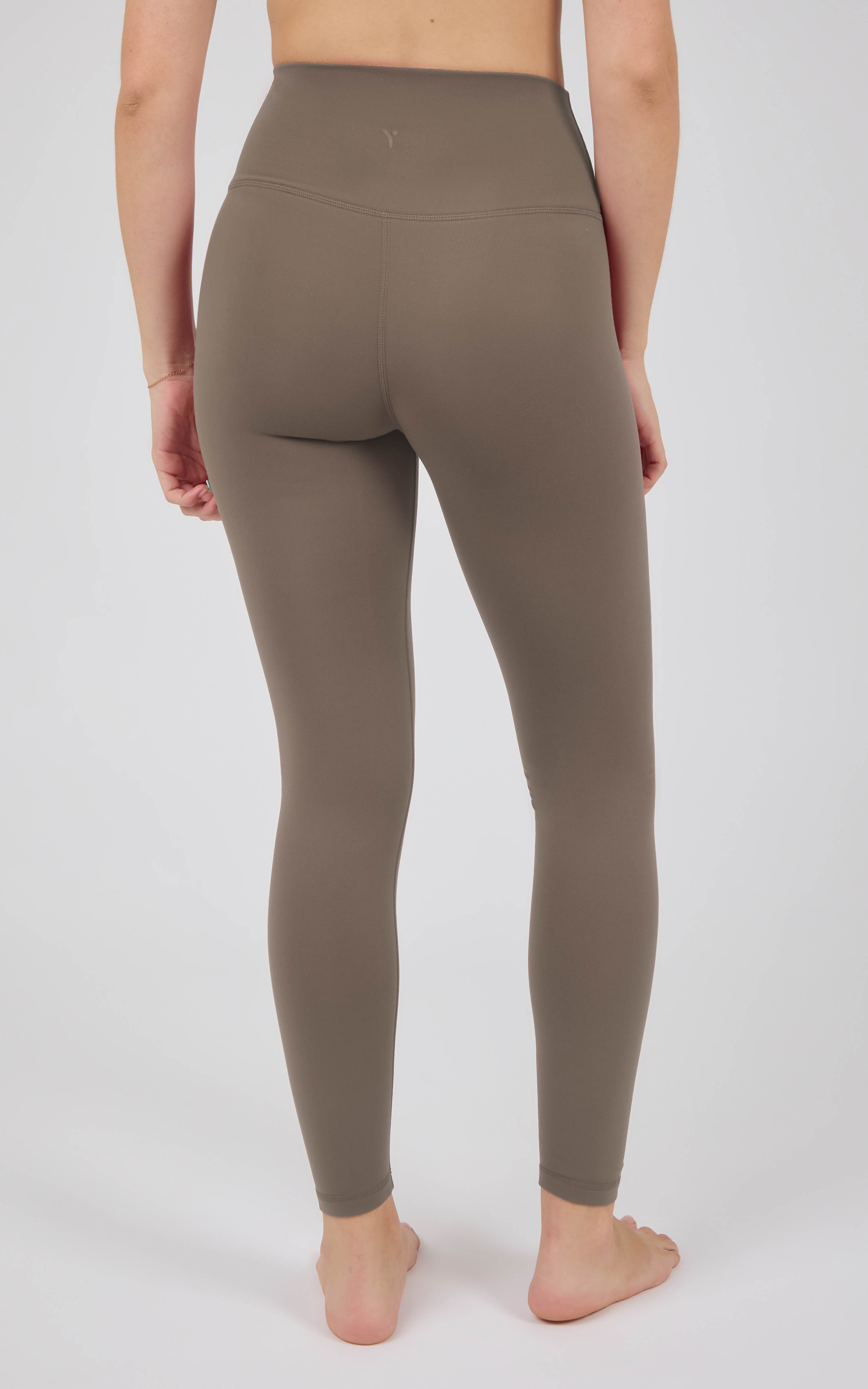 Taupe high-rise full-length leggings with a smooth, stretchy finish and a wide waistband, shown from the back.