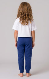 Back view of a girl wearing blue tapered joggers with an elastic waistband and cuffed ankles.