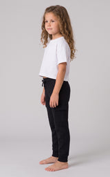Girl wearing black tapered jogger pants with a drawstring waist and side pockets.